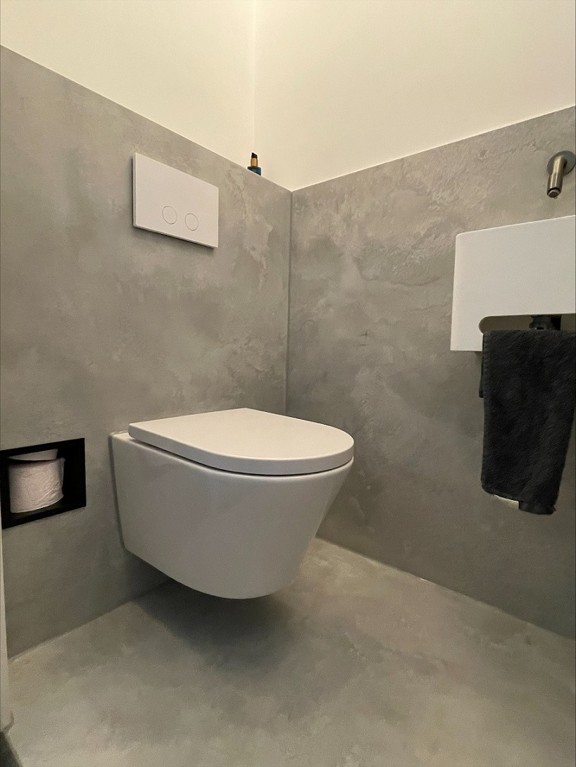 Toilet met grijze tegels in betonlook