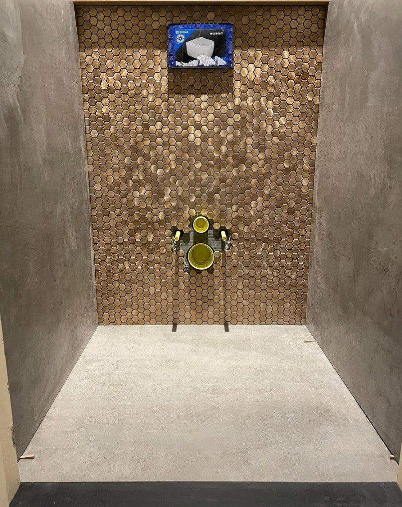 Toilet in Oosterhout met een wand van koperkleurig hexagon mozaïek