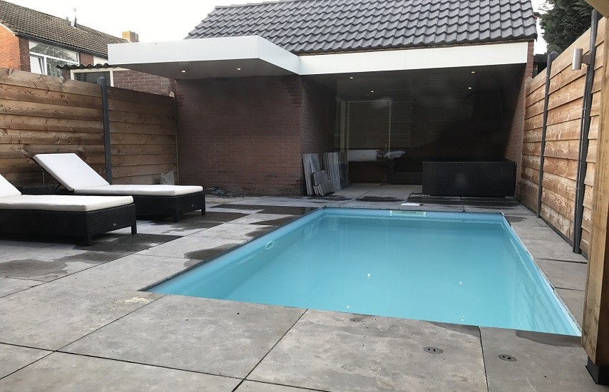 Tuin met zwembad, overkapping en houten schuttingen
